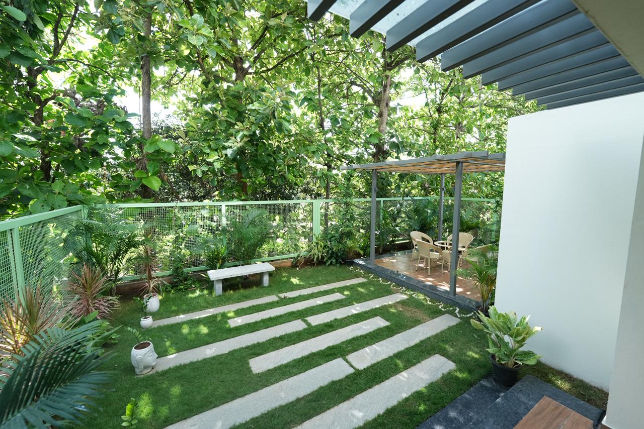Private backyard garden with stone pathway and pergola seating